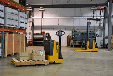 Two motorized pallet jacks being used for training purposes